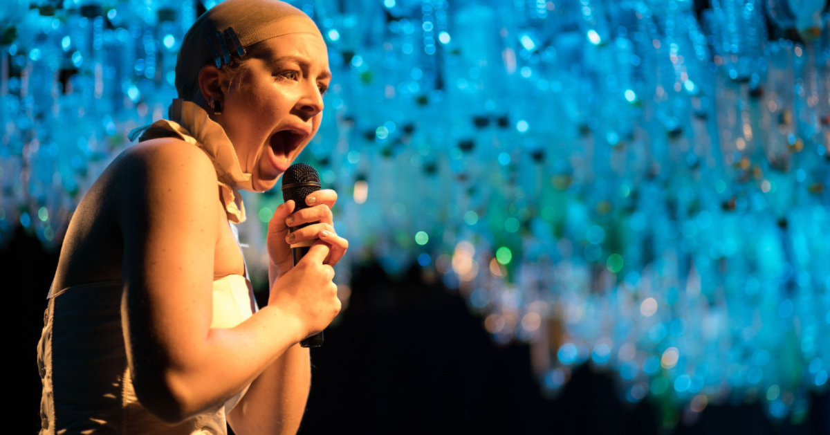 Woman stands on stage speaking