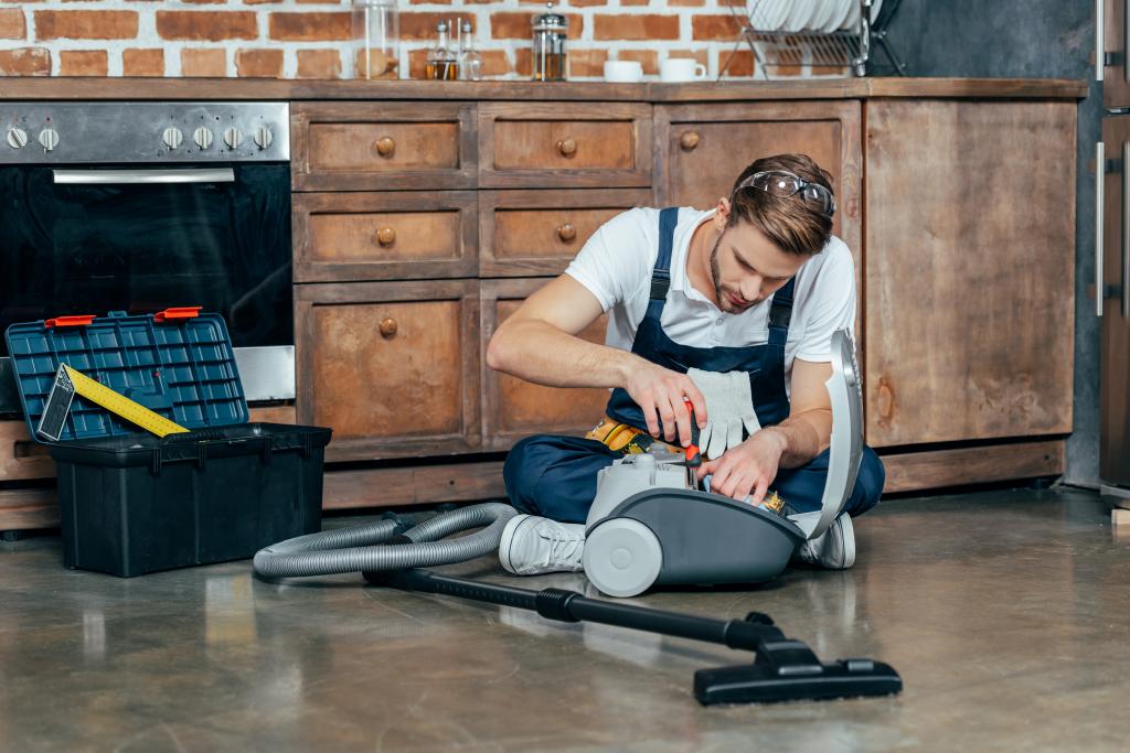 Man repairs a broken vacuum