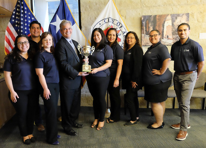 Business & Community Lenders of Texas employees receiving Green Cup Award from Austin Mayor Steve Adler