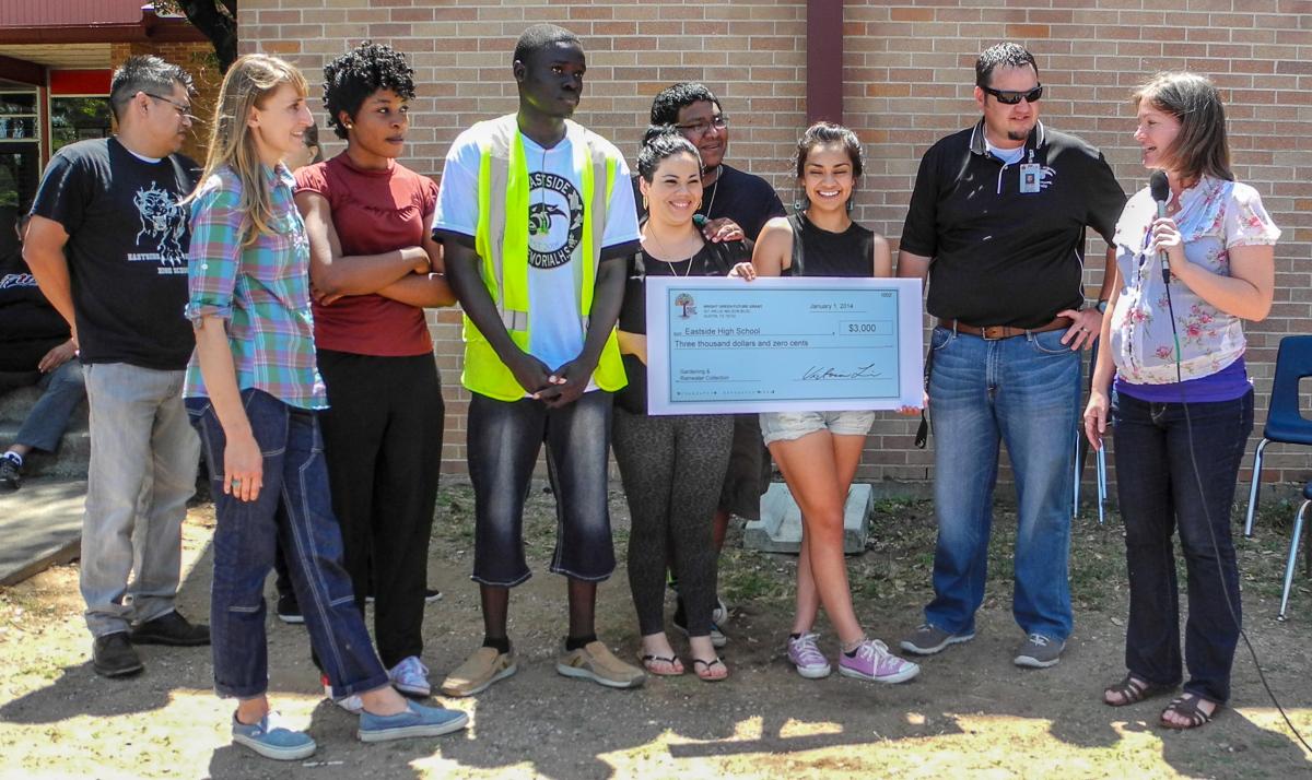 Students being presented with a big check for the project at their school.