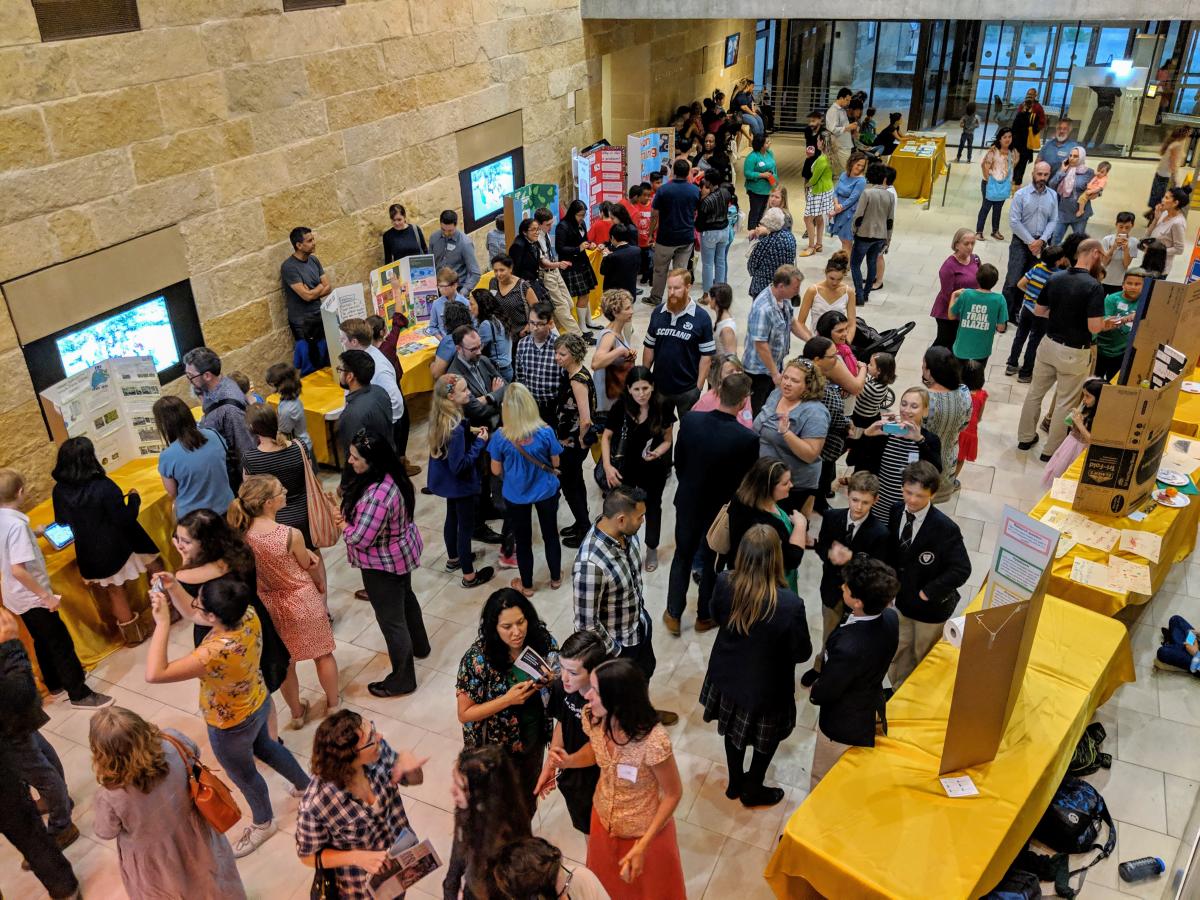 Photo taken from above in Austin CIty Hall. The atrium is full and buzzing with students and adults.