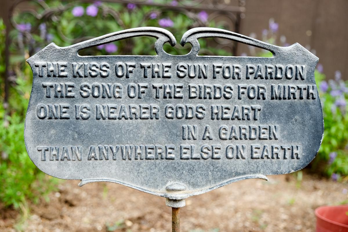 Garden sign reads: The kiss of the sun for pardon. the song of the birds for mirth, one is nearer gods heart in a garden, than anywhere else on earth.
