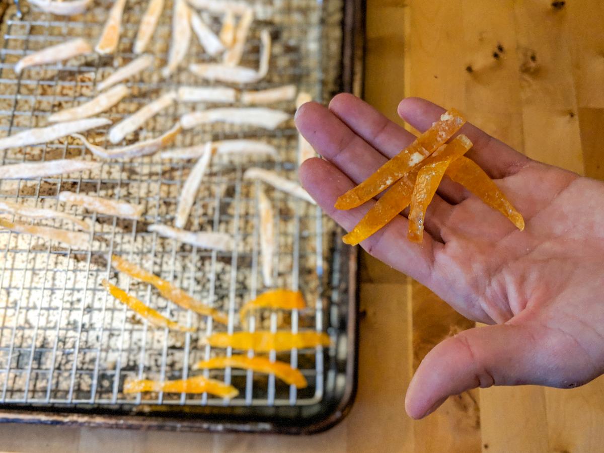 Candied citrus peels in a hand.