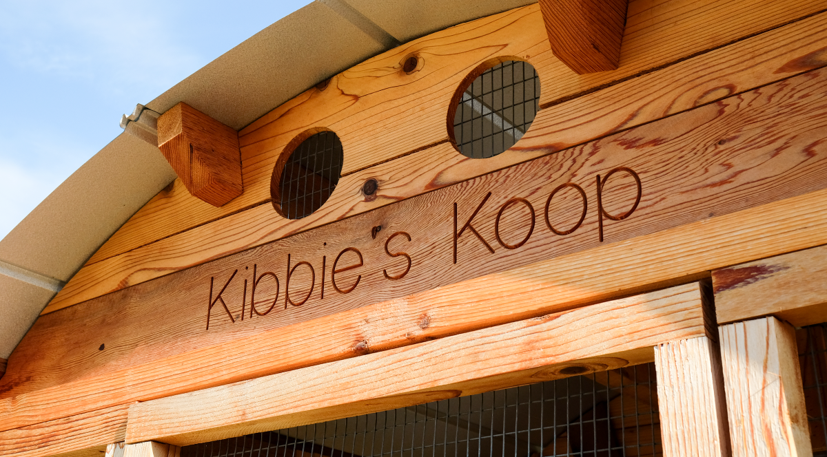 Detail shot of chicken coop that reads "Kibbie's Koop"