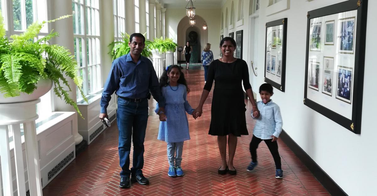 Asvini with her mother, father, and brother holding hands in the white house.