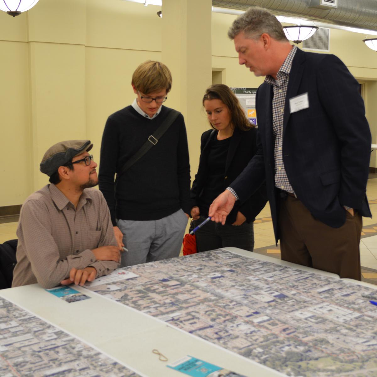 Photo of a group of people discussing a map.