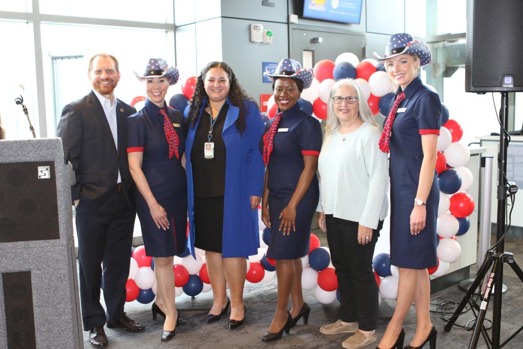 AUS and City of Austin representatives including Mayor Pro Tem Leslie Pool stand with British Airways stewardesses to pose for a picture during the 10th year celebration.