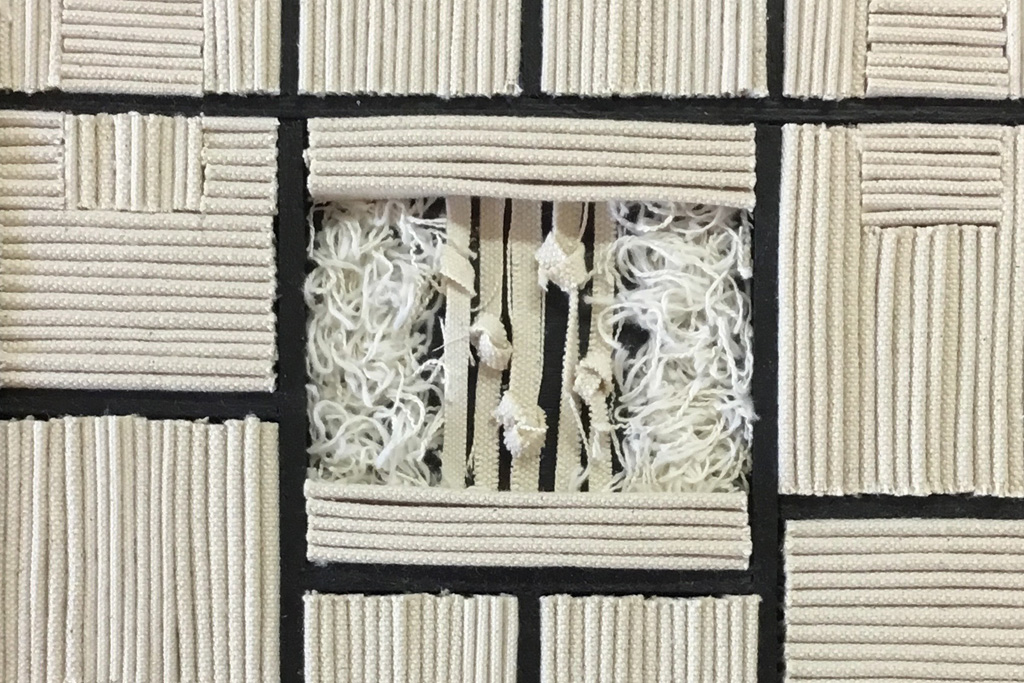 An image of artwork made up of pieces of rope that have been cut and arranged into squares