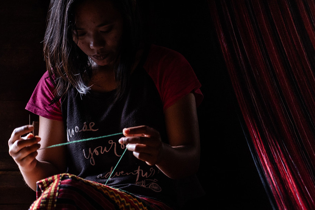 A photograph of a person sewing