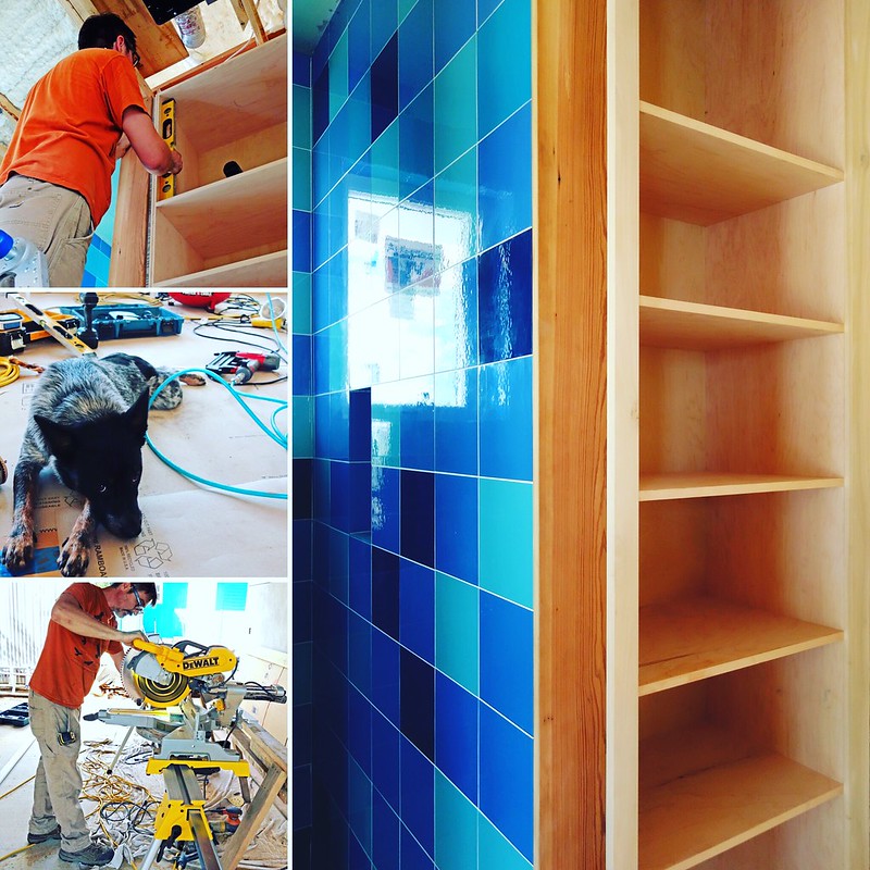 Person working on placing blue tile.