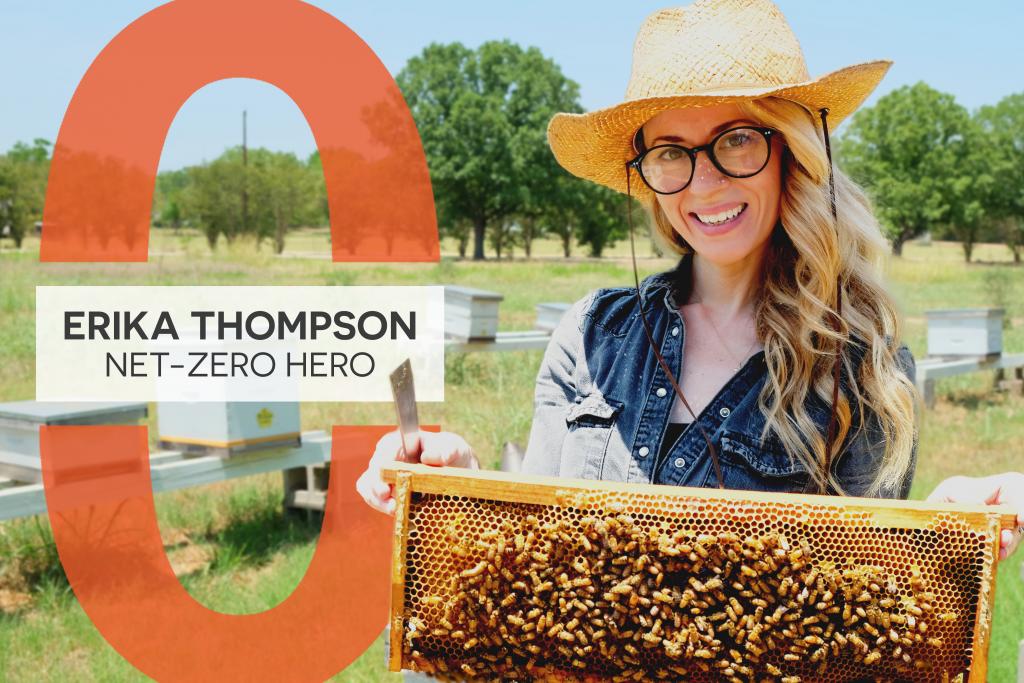 Ericka smiles at the camera holding a frame full of bees and honeycomb.
