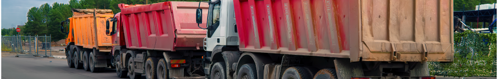 three dump trucks lined up on the street