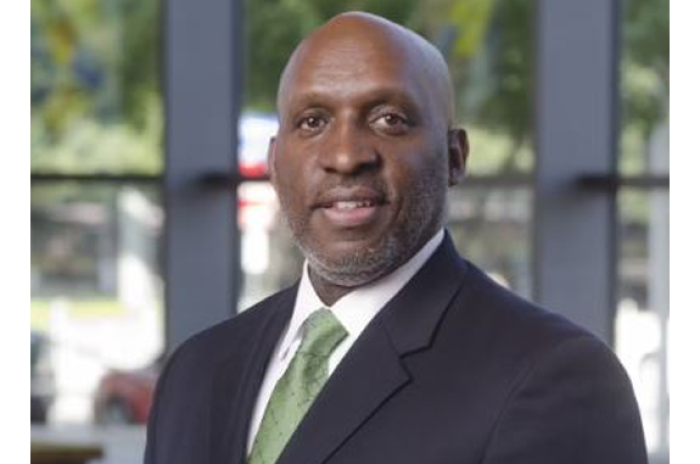 Picture of new Austin City Manager TC Broadnax wearing a dark gray suit with a white shirt and light green tie.