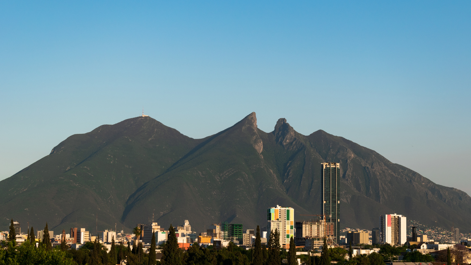 Mountain range in the background. Downtown city with buildings. 