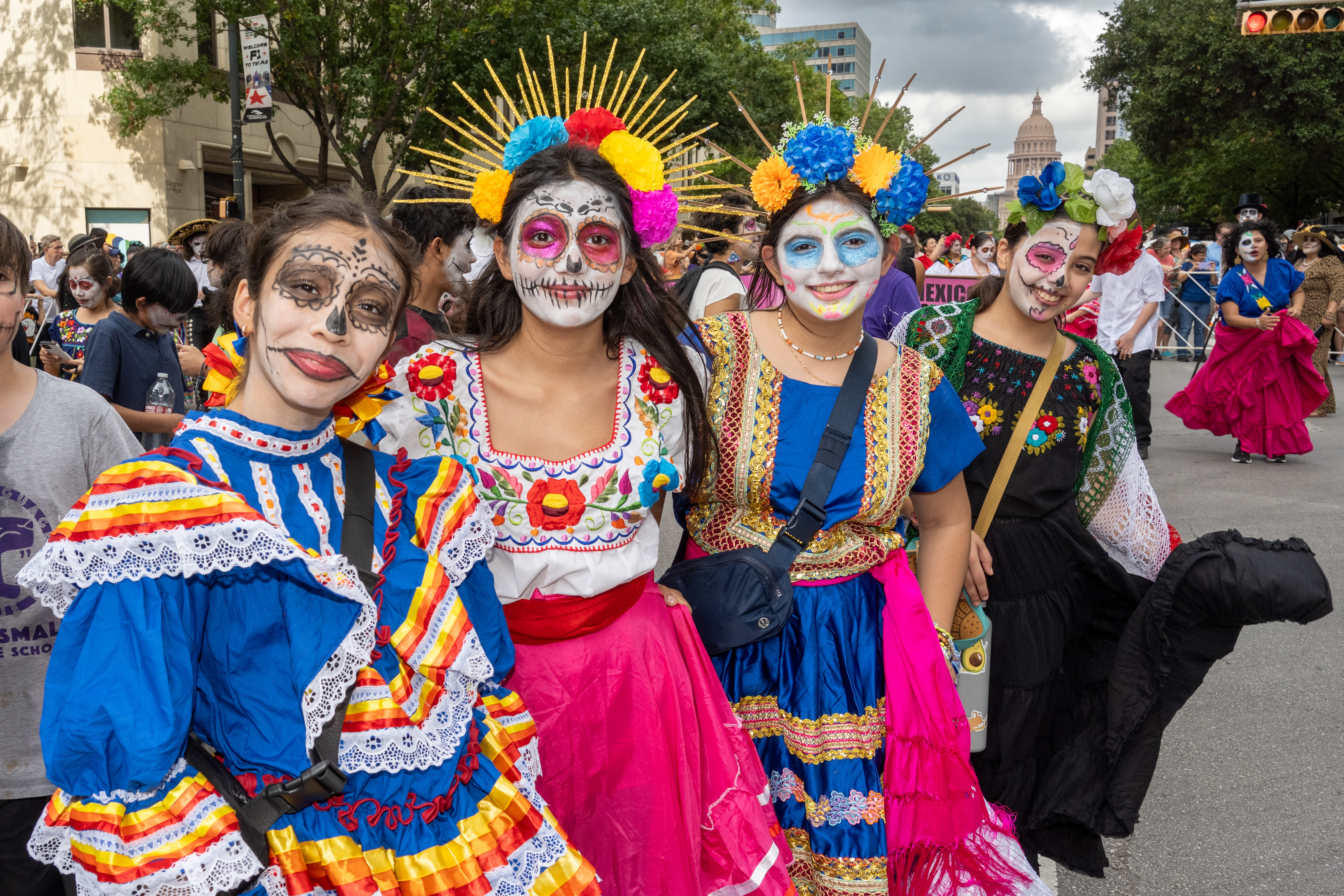 four ladies at the 2023 festival dressed in colorful costumes with painted faces and flower crowns