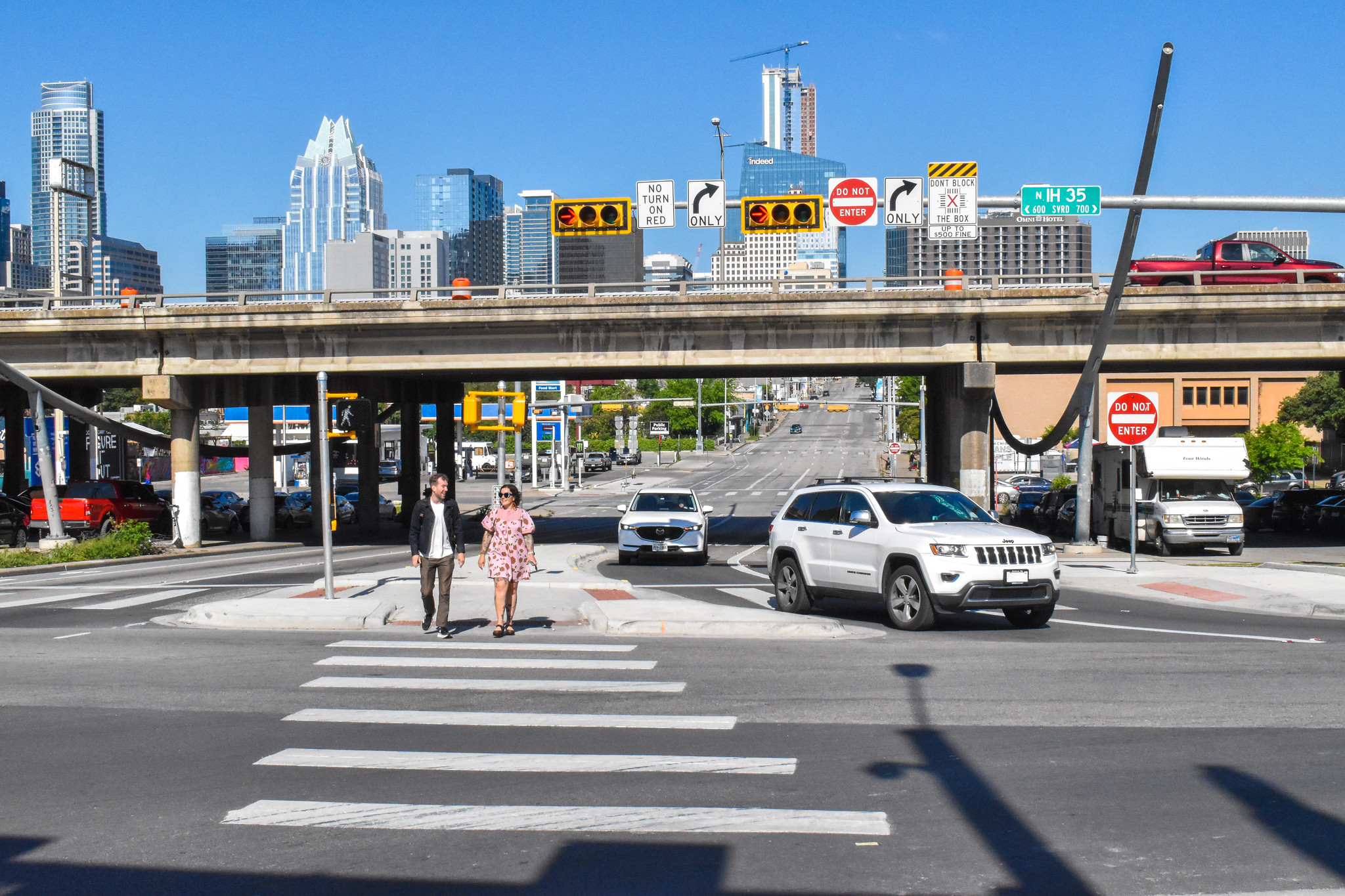 People crossing Interstate 35 frontage road at Seventh Street via improved crossing.