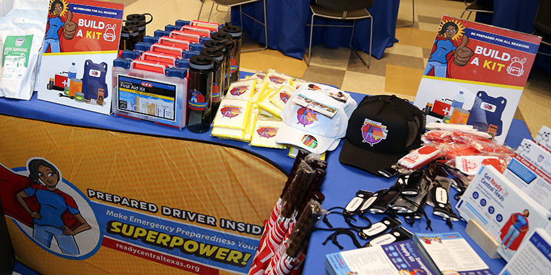 photo displaying a table with emergency supplies and sign reading "Build a Kit". 