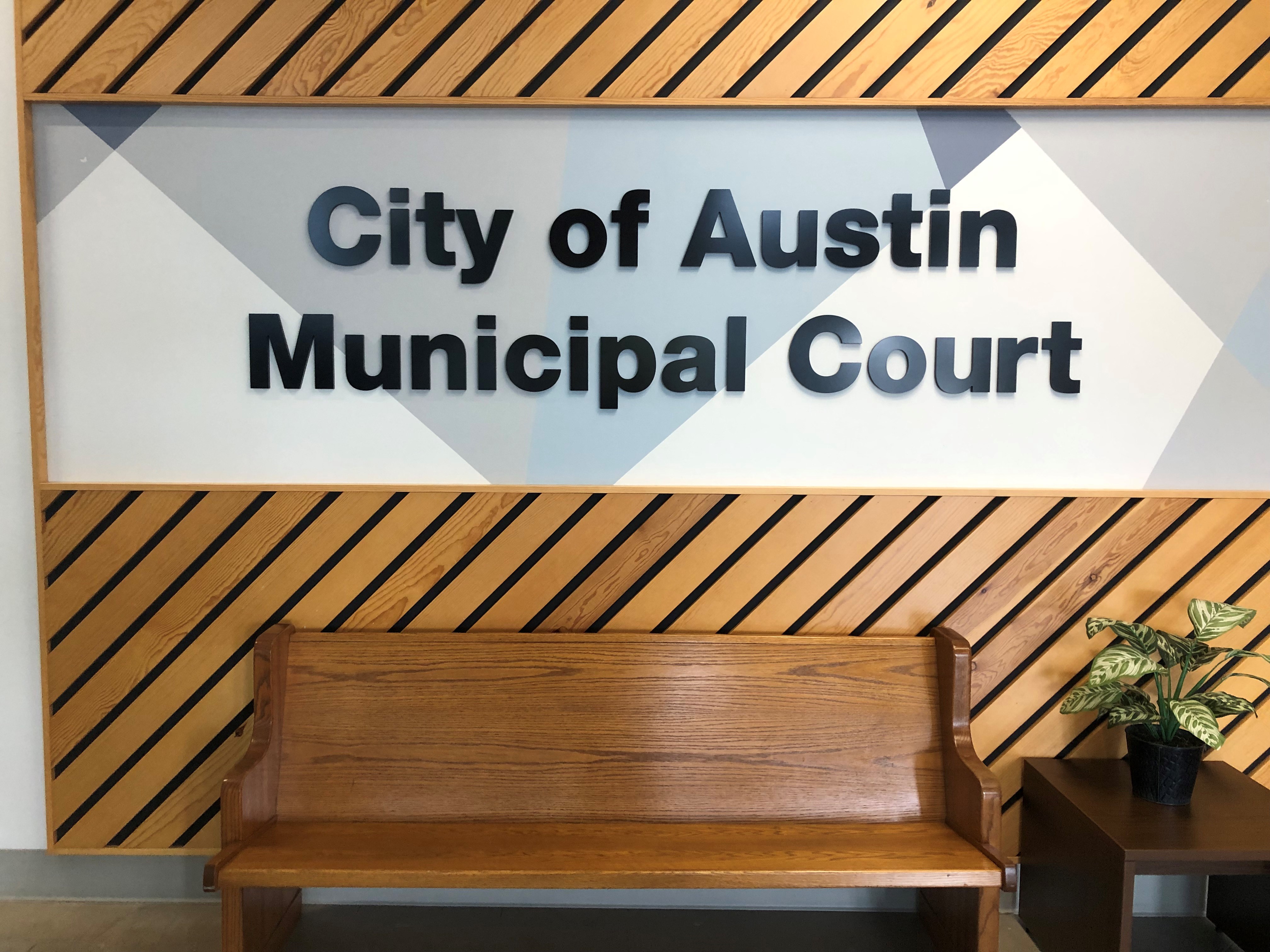 Brown bench in front of wall in the hallway of the Municipal Court building.