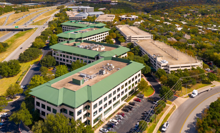 Image of three buildings in a row with green rooftops