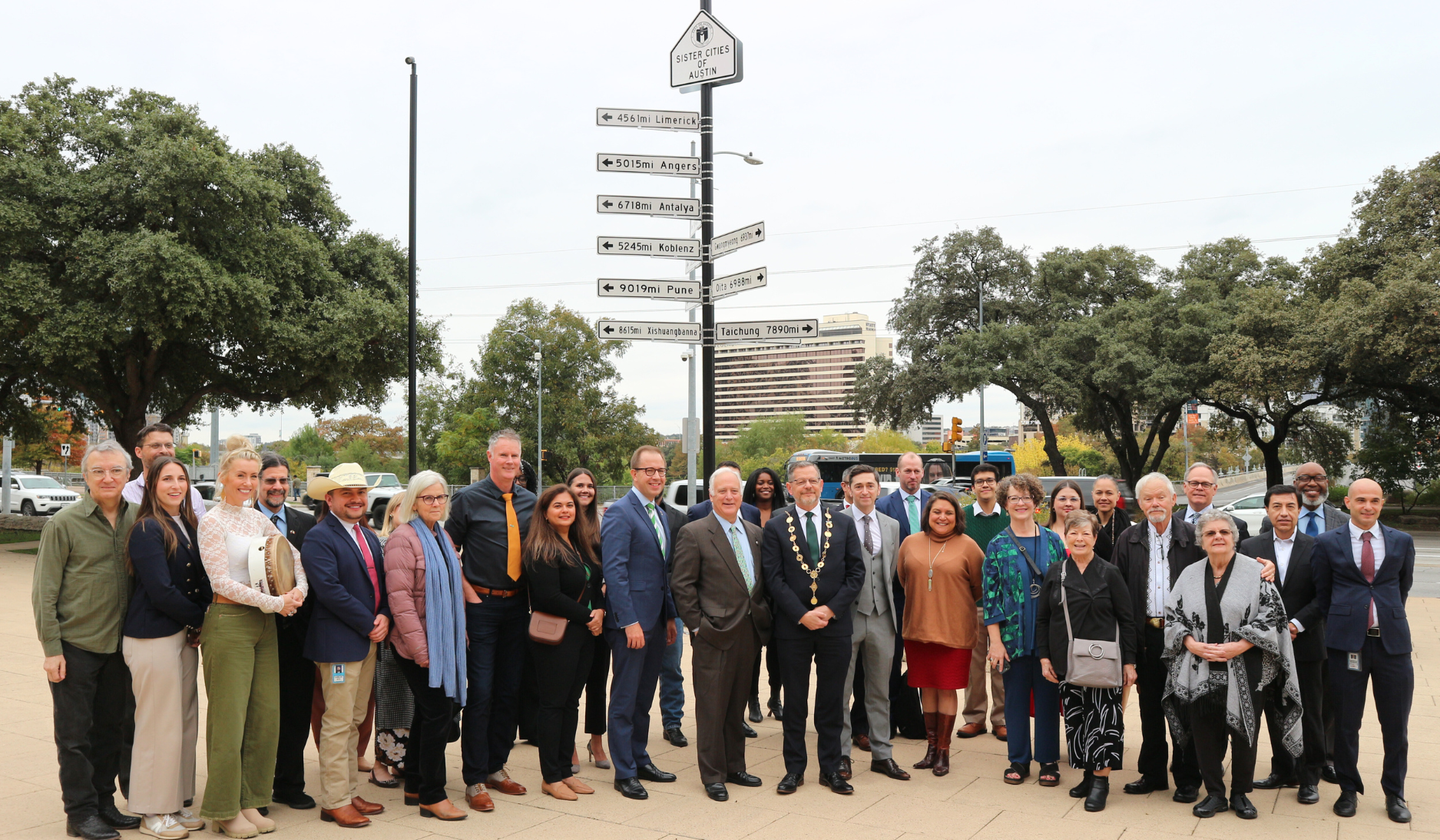 People standing together in front of the Sister Cities signage located in front of Austin City Hall 