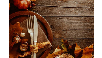 Photo of wood table with a knife and fork and napkin on it