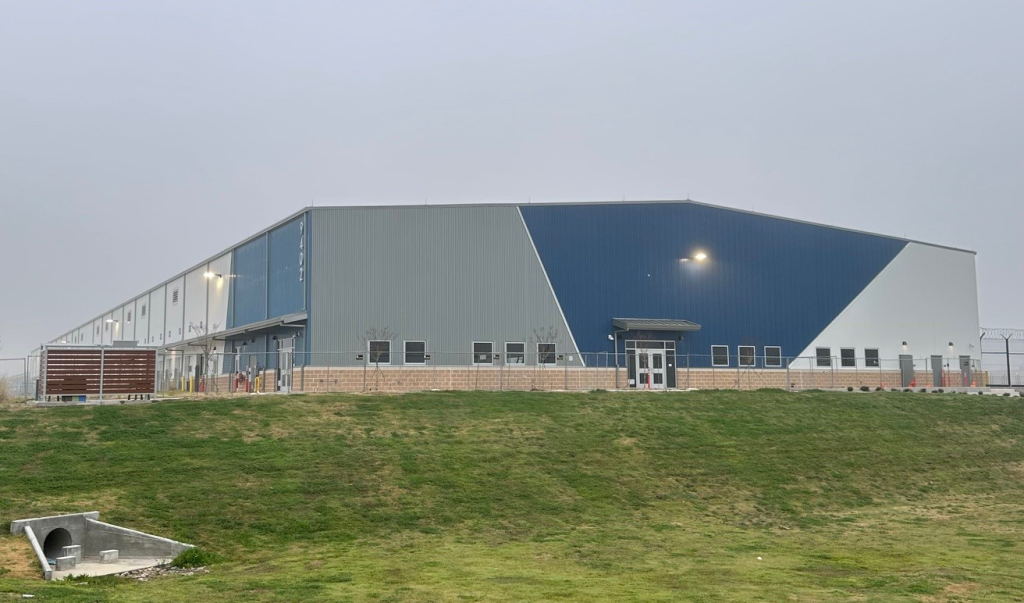 Photo of new air cargo facility, showing a gray and blue building.