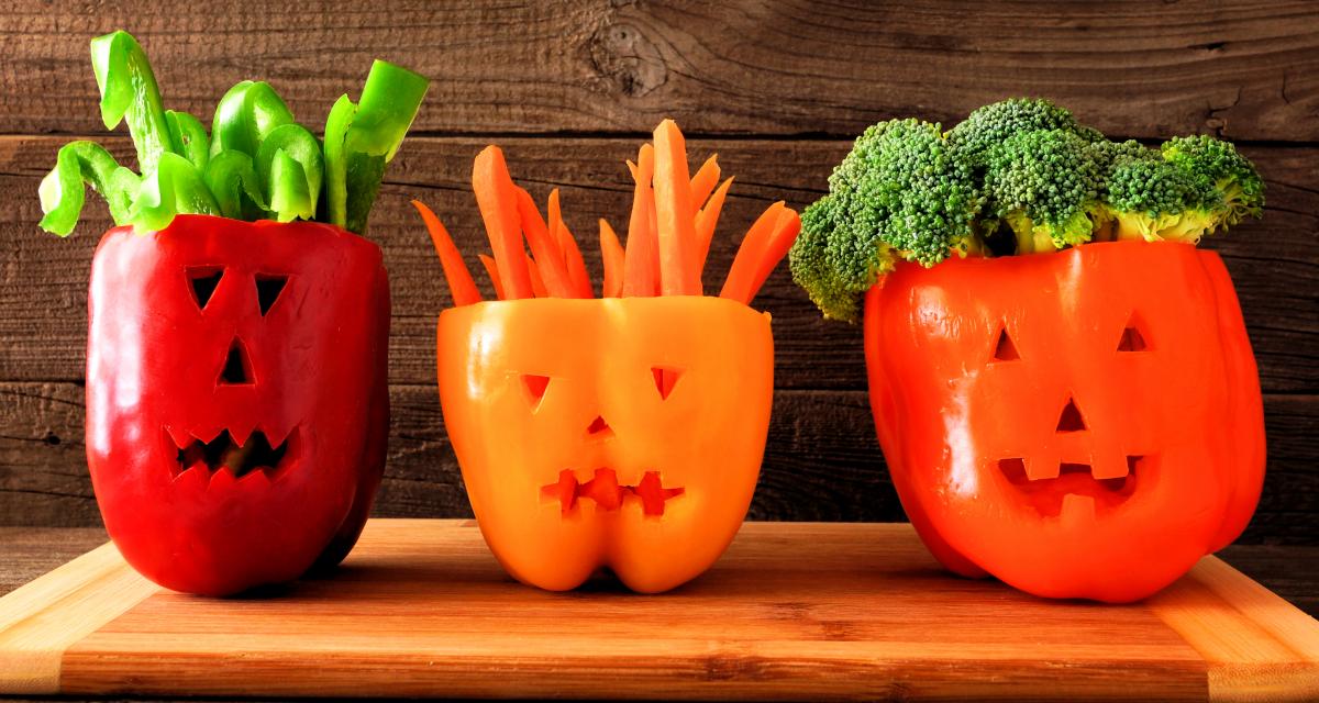 Bell peppers cut into jack-o-lanterns and used to serve cut veggies in.