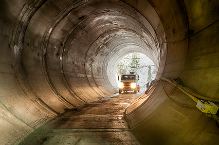 Photo of truck driving through tunnel during construction.