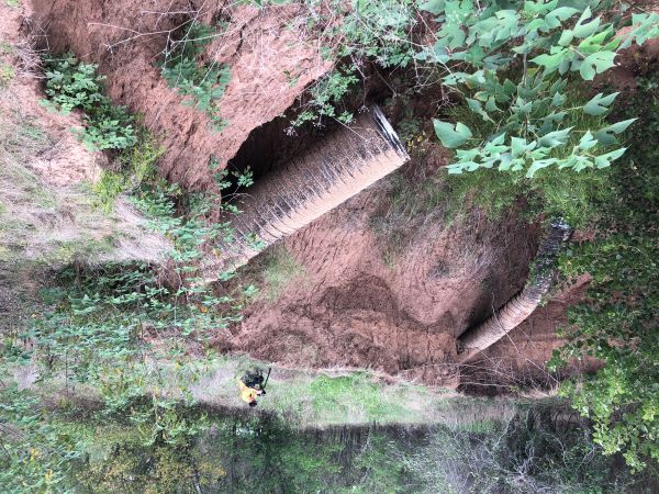 Photo showing two broken pipes in canyon.