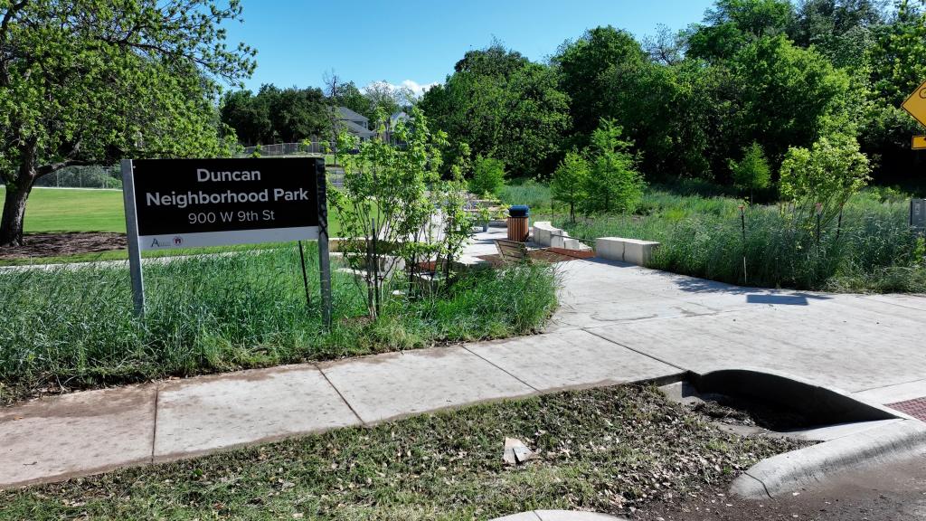 Photo of the entry way and ID sign for the newly improved Duncan Neighborhood Park, showing new benches, paths, and landscaping.