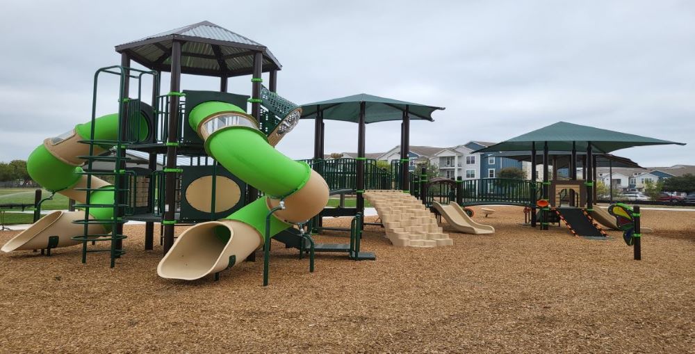 New play structures at Oertli Park with apartments in background