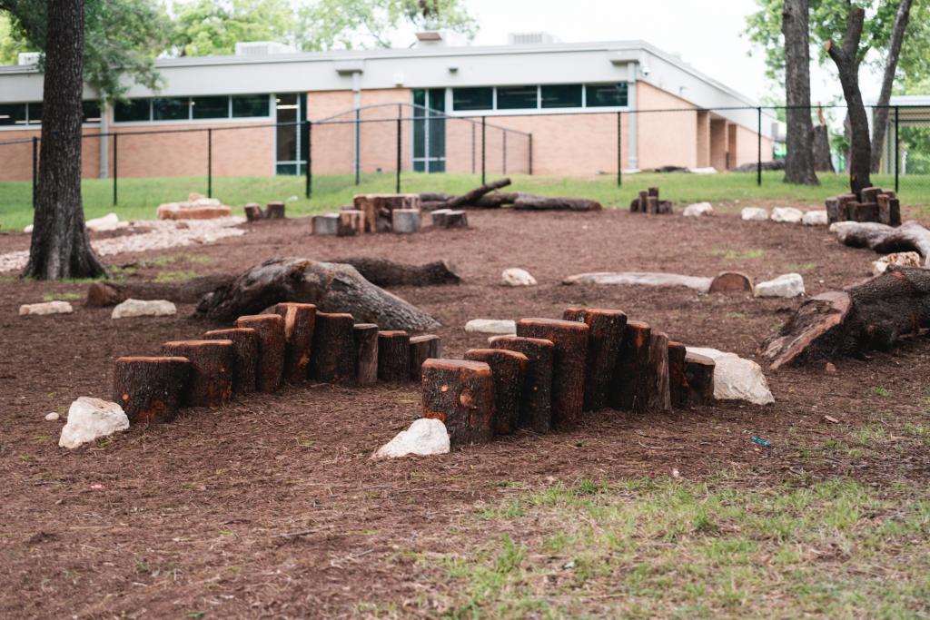 Playground with natural elements. Tree stumps, logs and rocks. 