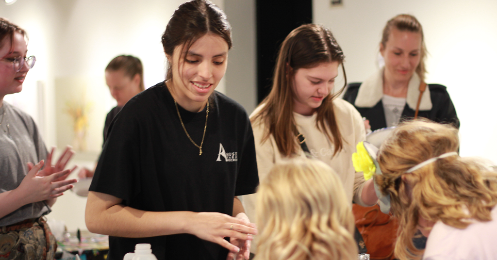 A photo of several people interacting with one another many of which are young adults.