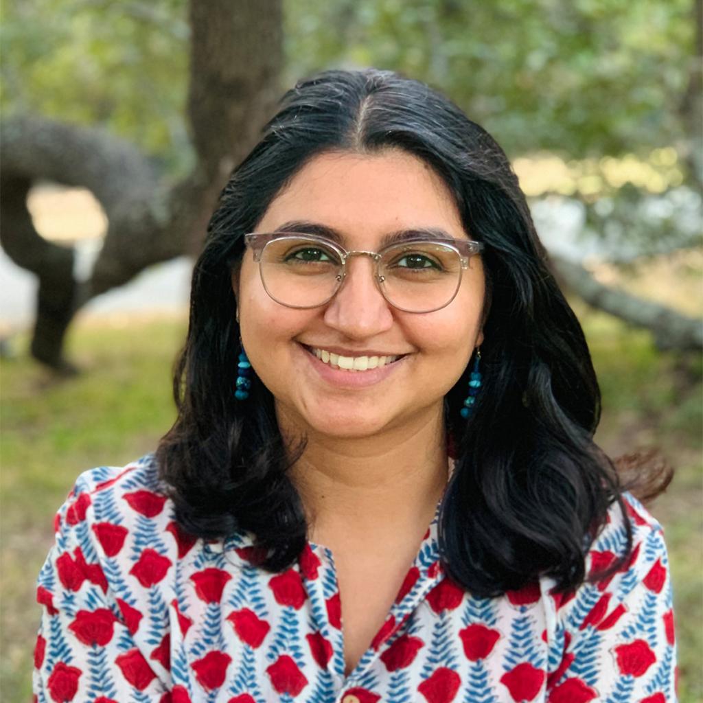 A photograph of artist Gargi Sharma smiling and making eye contact with the viewer