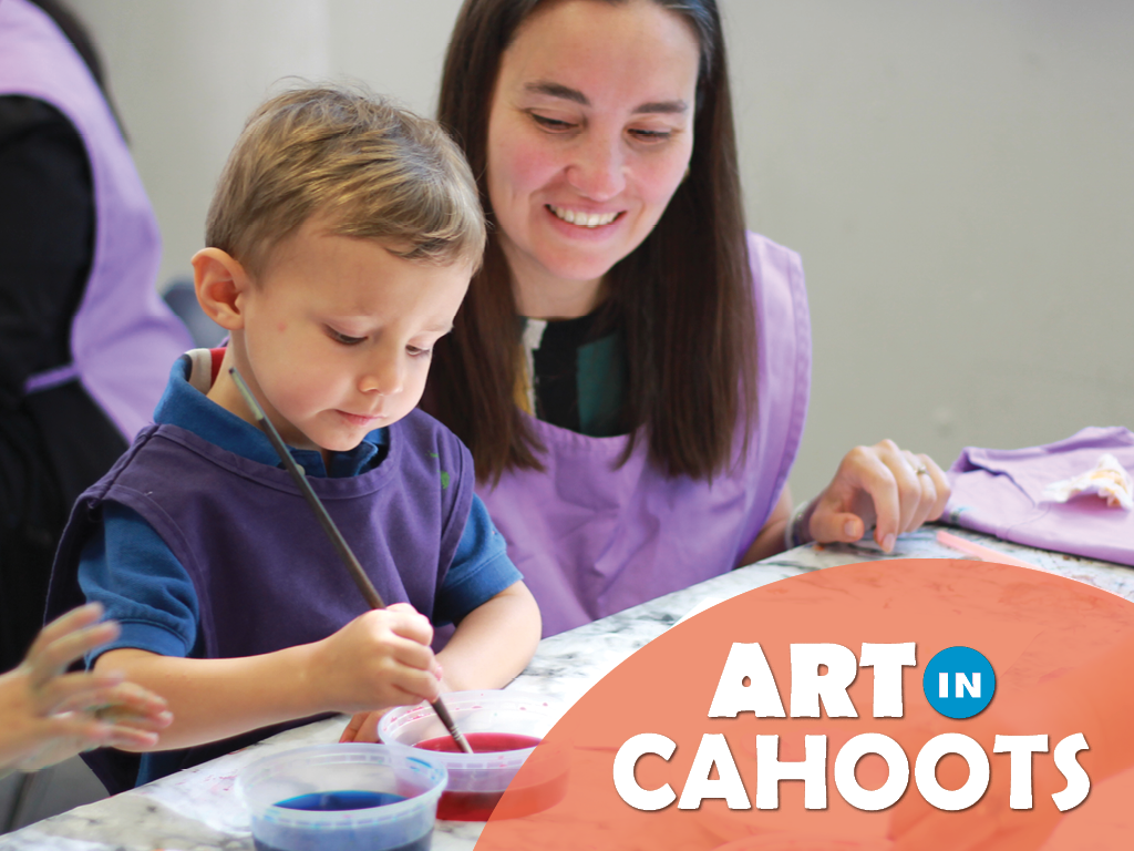 An image of a child and an adult at a table. The child is dipping a paintbrush into paint. Text on the image says 'Art In Cahoots'