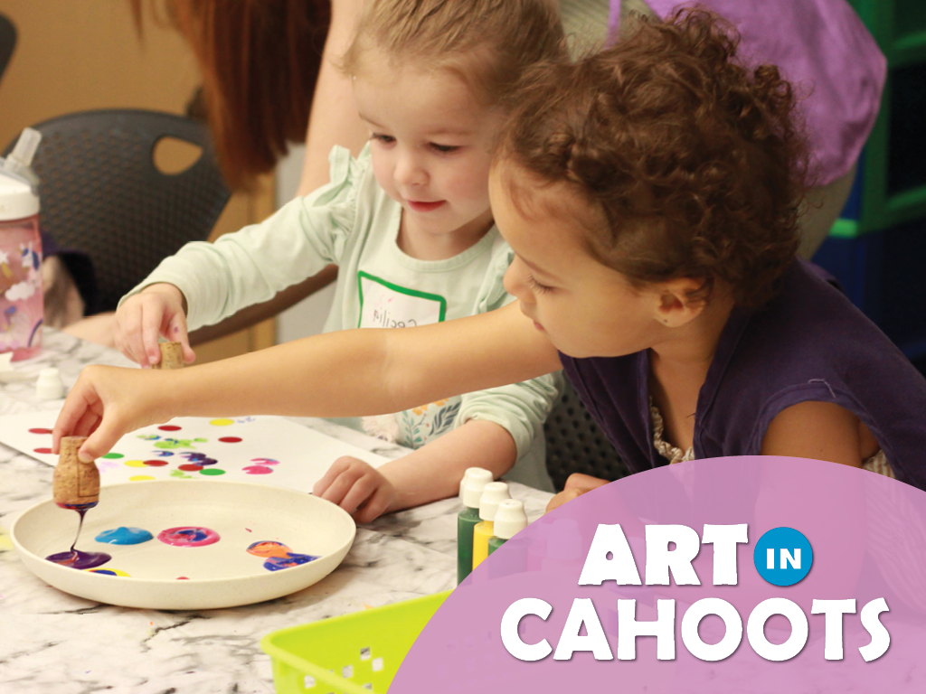 Two children creating art by dipping a cork in paint and the text 'Art In Cahoots'