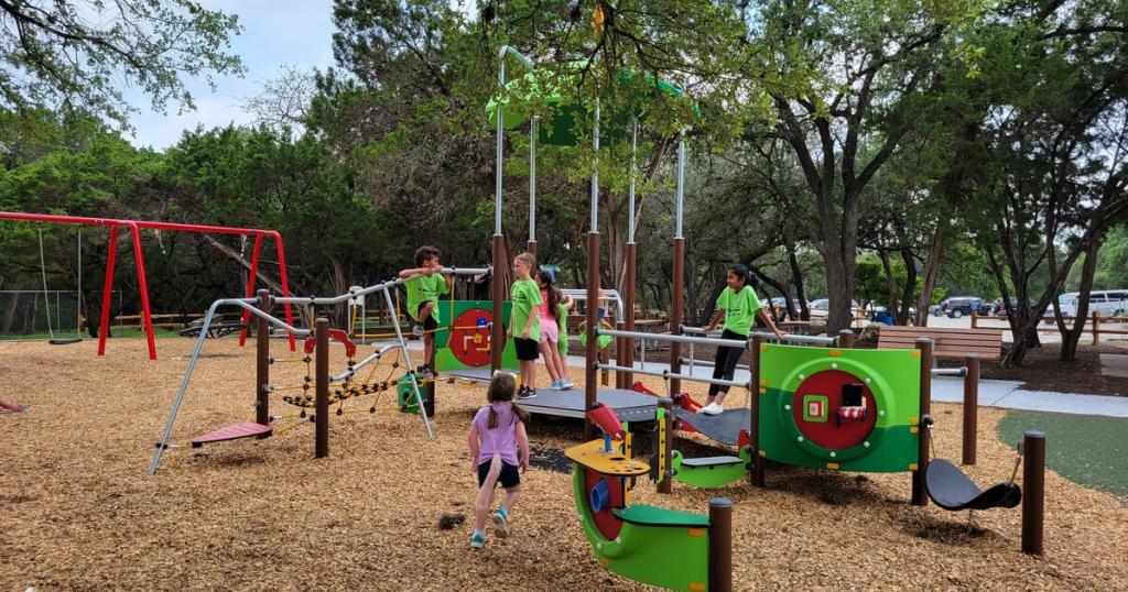 Youths gathered on new playground equipment at Walnut Creek Park