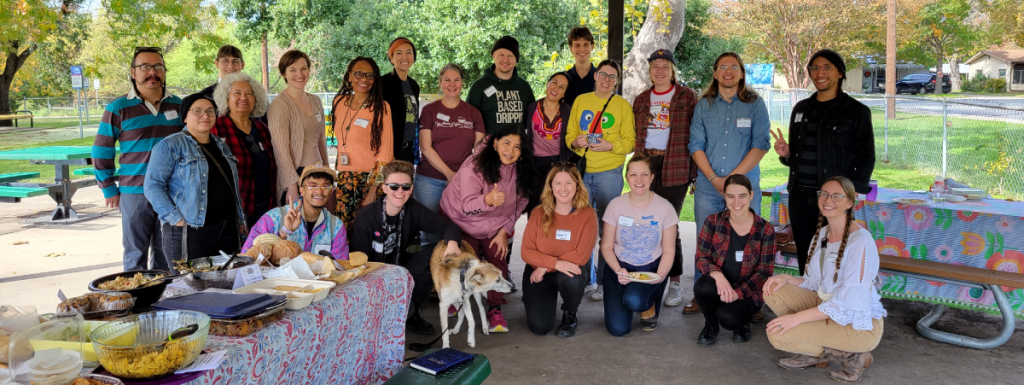 A group of folks outside in front of picnic tables.