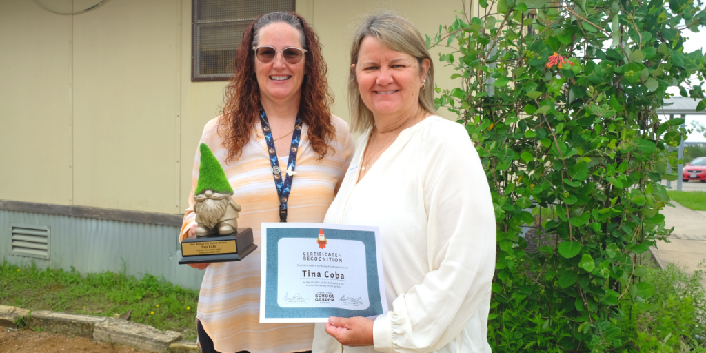 Mary K. Priddy and Tina Coba pose at the Overton Elementary School gardens with the Golden Gnome trophy and Tina's certificate.