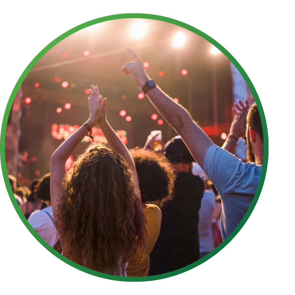 People cheer at an outdoor concert.