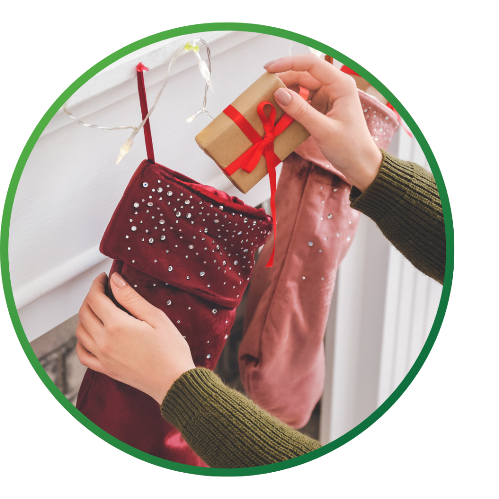 A close up on hands placing a simply wrapped, small gift in a stocking.