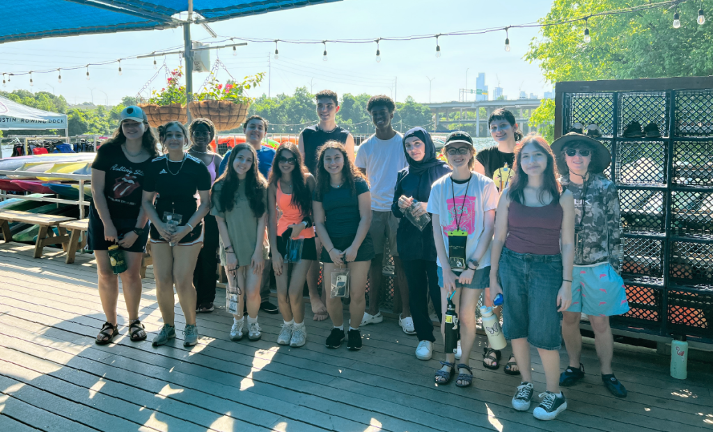 A group of young people stand on a dock over Ladybird Lake.