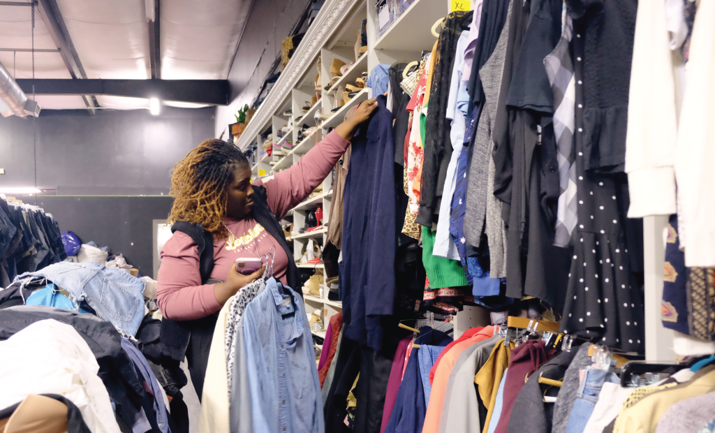 A shopper pulls clothes from the shelves of Heartening.