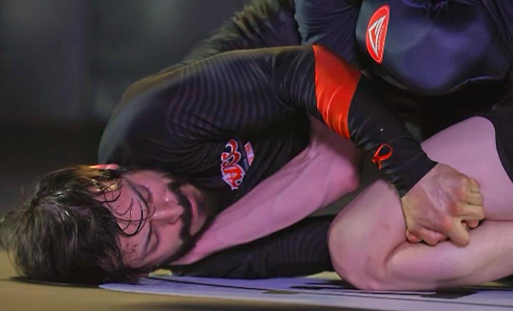 Troy on a mat competing in jiu-jitsu with another competitor.