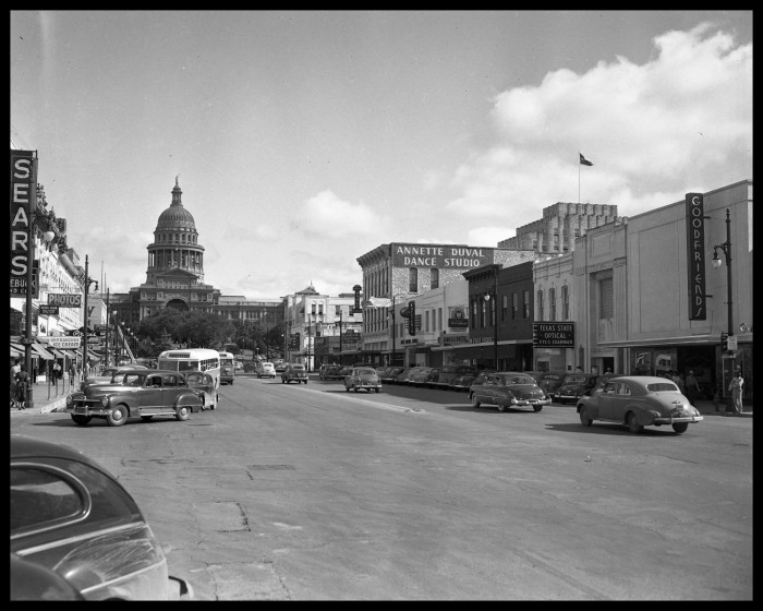 A vintage photograph of Congress Avenue looking north from 9th Street towards the State Capitol