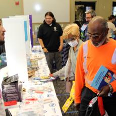 A photo showing community members visiting a preparedness booth at a pop-up event at a library.