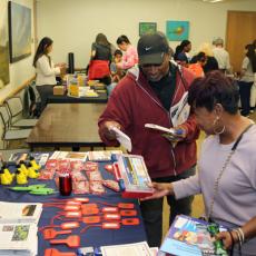 A photo showing community members visiting booths and getting free items at an Emergency Preparedness Pop-up event.