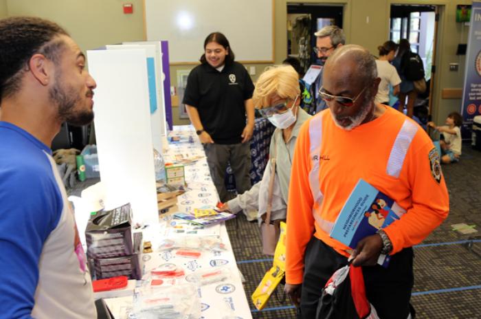 A photo showing community members visiting a preparedness booth at a pop-up event at a library.