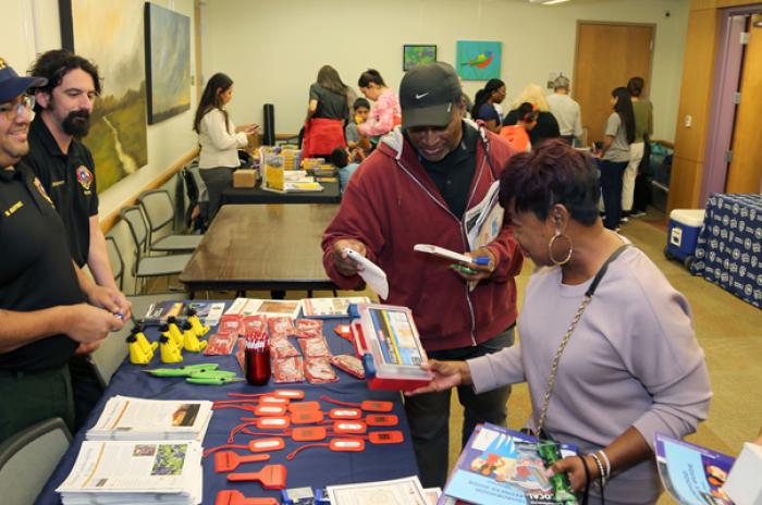 A photo showing community members visiting booths and getting free items at an Emergency Preparedness Pop-up event.