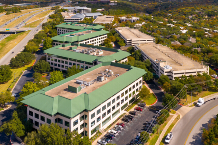 Image of three buildings in a row with green rooftops